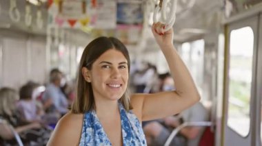 Güzel İspanyol kadın, kameraya gülümsüyor boş bir metro treninde, şehirli kızın neşeli transit portresi