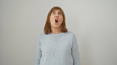 Orta yaşlı bir kadın öfkeyle bağırıyor, beyaz bir arka planda izole edilmiş, güçlü bir duyguyu canlandırıyor..