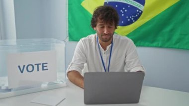 İspanyol asıllı genç adam gülümseyip başparmağını kaldırırken Brezilya seçim okulunda bilgisayar kullanarak olumlu onay ve mutluluk işareti gösteriyor.