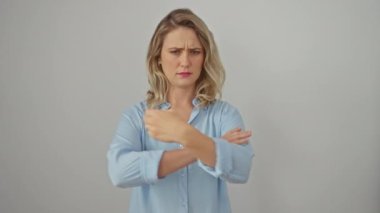 Gergin genç sarışın kadın gömlek giyiyor, kollarını kavuşturuyor, kuşkucu bir ifade takınıyor. Yüzü onaylamadığını gösteriyor, negatif titreşimler yayıyor. beyaz arkaplanda izole.