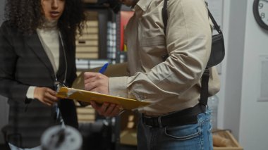 Bir kadın ve bir erkek dedektif olarak iş birliği yapıyor, ofiste notlar alıyorlar, kapalı bir polis soruşturması öneriyorlar..