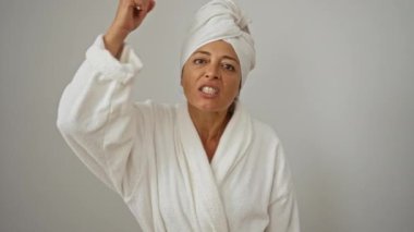 Bornoz ve havlu giymiş bir kadın öfkeli bir ifadeyle seni işaret ediyor, kızgın ve üzgün, orta yaşlı kadın beyaz arka plan yüzünden tecrit altında.
