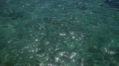 Puglia, İtalya 'da Porto Sezaryeni açıklarında parlak, berrak su. Güneş ışığını yansıtıyor ve Salento bölgesinin güzelliğini gösteriyor..