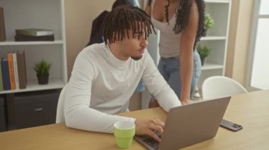 Oturma odasında bir adam ve bir kadın dizüstü bilgisayara bakıyor, aşk, ilişki ve ev hayatını çağrıştırıyor..