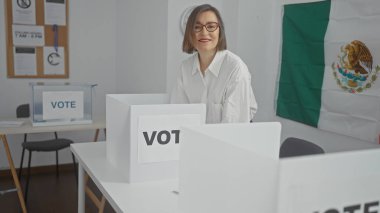 Meksika seçim odasında oy kullanma kabinleri ve bayrağıyla gülümseyen olgun bir kadın.