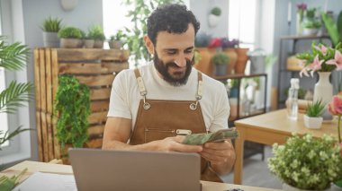 Sakallı, orta yaşlı bir adam canlı bir çiçekçide Arap emirlikleri sayıyor..