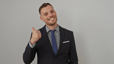 Takım elbiseli gülümseyen adam beyaz bir arka plana başparmak işareti yapıyor.