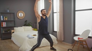 Orta yaşlı bir adam modern bir yatak odasında esniyor, sağIık duygusu ve sabah rutini yaratıyor..