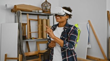 Yaratıcı bir atölyede VR kulaklık takan gülümseyen kadın.