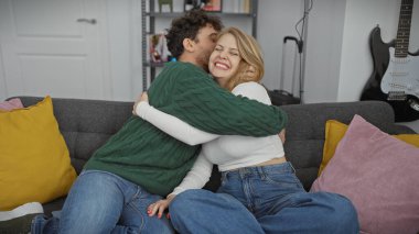 Sevgi dolu bir çift, sıcak ve sevgi dolu, renkli bir oturma odası ortamında neşeyle kucaklaşır..