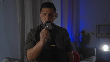 Aydınlatılmış karanlık oturma odasında rozeti olan İspanyol dedektif içeride kolluk kuvvetlerini canlandırıyor..