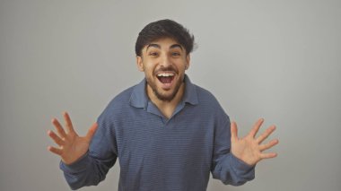 Sakallı mutlu genç adam beyaz bir arka planda izole edilmiş neşeyi ifade ediyor.