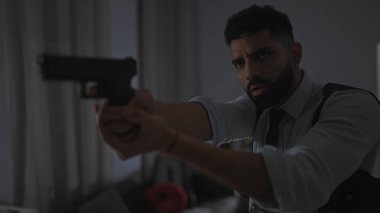 Odaklanmış sakallı İspanyol bir adam tabancayı içeri doğrultur. Gerginlik ya da suç mahalli izlenimi uyandırır..