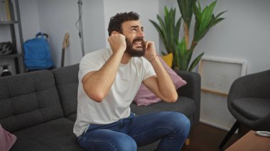 Sıkıntılı bir adam kulaklarını kapalı bir koltukta otururken gürültüden rahatsız olur..