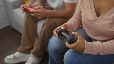Irklar arası çift, rahat bir oturma odasında video oyunu oynuyor, boş zamanlarını ve teknolojilerini sergiliyorlar..
