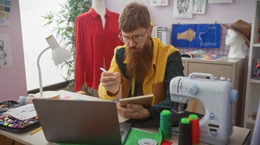 Kızıl saçlı adam terzi dükkanında notlar alıyor. Etrafı dikiş malzemeleri, manken ve kıyafetlerle çevrili..