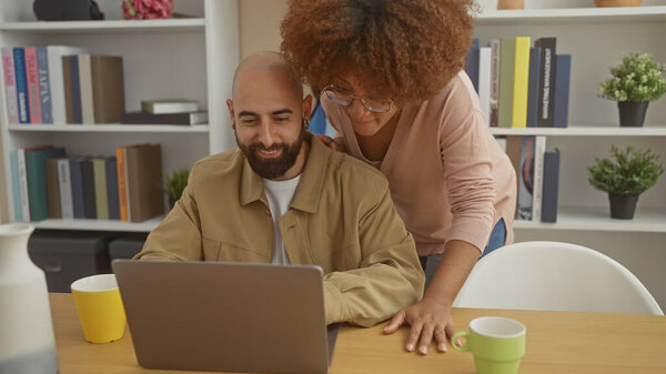 An interracial couple enjoys a moment together in a cozy interior with a laptop, signifying a connected, modern lifestyle.