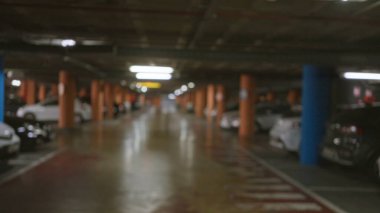 Bulanık arabalarla ve bokeh efektleriyle yeraltı otoparkında odağını kaybetmiş aydınlatma şehir atmosferini ve gizemli ambiyansı taşır.