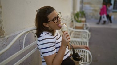 Genç İspanyol kadın tatlı bir kasabanın atmosferinde Lecce, Puglia, İtalya 'da dondurma yiyor..