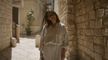 Güzel, genç, İspanyol bir kadın. Güneşin altında gülümsüyor. Bari 'nin Puglia, İtalya' daki eski kasabasının sokaklarında..