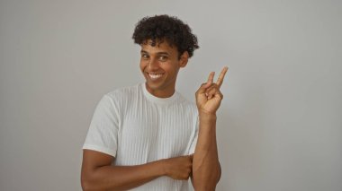 Yakışıklı bir adam beyaz bir arkaplanda izole edilmiş bir barış işareti veriyor.