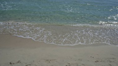 Salento, Puglia 'daki Porto Sezaryen Sahili' nin kumlu kıyısı, yumuşak ve berrak su dalgalarıyla kıyıya vuruyor..