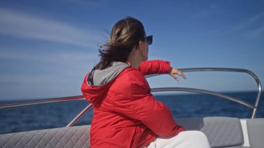 Polignano 'da bir teknede genç bir İspanyol kadın kısrak, puglia, İtalya, güneşli bir günde deniz ve körfez manzarasının tadını çıkarıyor..