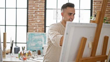 Parlak bir sanat stüdyosundaki tuvale resim yapan genç bir İspanyol.
