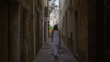 Genç bir İspanyol kadın polignano 'nun büyüleyici sokaklarında yürüyor. Puglia, İtalya' da bir kısrak. Bu güzel Avrupa bölgesinin özünü yakalıyor..