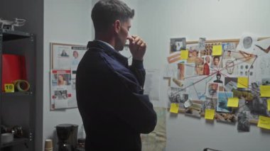 Düşünceli İspanyol erkek dedektif soruşturma kuruluyla birlikte suç delillerini inceliyor.