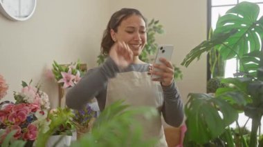 Heyecanlı genç İspanyol çiçekçi zaferi kollarını kaldırarak kutluyor. Kapalı bir çiçekçide başarıyla bağırıyor.