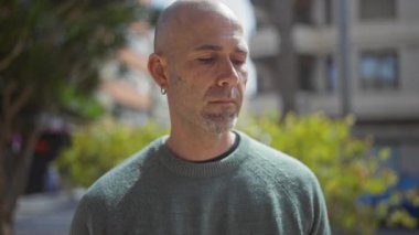 Sakallı, sakallı, sakin, kel bir adam şehir parkında huzurlu bir anın tadını çıkarıyor..