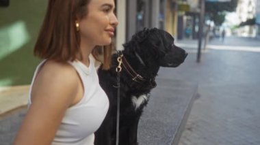 Labrador köpeğiyle şehir sokaklarında gezen genç bir kadın evcil hayvanıyla şehir yaşamını açık havada sergiliyor..