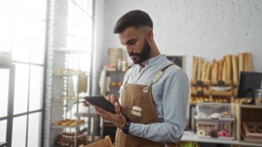 Fırında ekmek ve hamur işleri kullanan genç adam, önlük giymiş, odaklanmış, çalışıyor, modern dükkan, iyi aydınlatılmış iç mekan