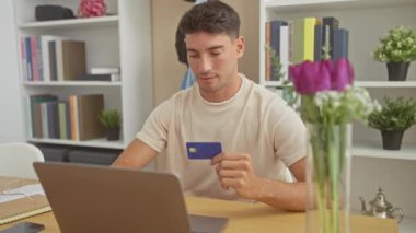 Evdeki ofiste elinde laptop ve çiçekle gülümseyen yakışıklı İspanyol adam..