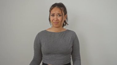 Genç, şüpheci İspanyol kadın alaycı bir bakış atıyor, ağzı inançsızlıkla açık. Beyaz bir arka planda tek başına duruyor, yüzü şüphe ve şaşkınlık portresi gibi..
