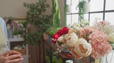 Çiçekçi bir kadın çiçekçide zarif ve huzurlu bir atmosfer çizerek güzel buketler düzenler..