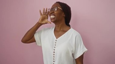 Genç Afro-Amerikalı kadın, gözlüklü, ağzı açık bir şekilde haykırıyor ve avazı çıktığı kadar bağırıyor, pembe arka planda, yoğun bir iletişim kuruyor.