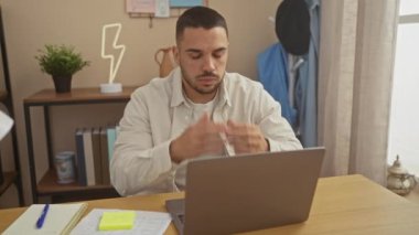 Stresli bir İspanyol evdeki bir ofiste dizüstü bilgisayarının başında oturuyor. Yorgunluk ve hayal kırıklığını yüzünden belli ediyor..