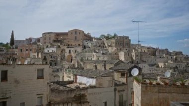 İtalya, Basilicata 'daki tarihi materyanın panoramik manzarası, mavi gökyüzüne karşı köyün eski taş binalarını sergiliyor..