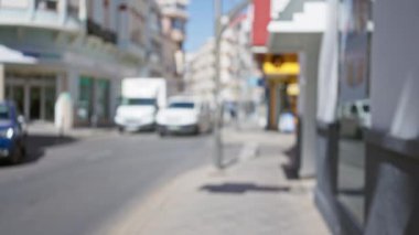 Güneşli bir günde araçların ve binaların olduğu bulanık cadde manzarası