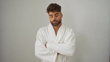 Morali bozuk, bornoz giymiş genç bir adam beyaz arka planda duruyor. Üzgün ifade, ağlama, endişe, öfke, sıkıntı, korku, yalnızlık ve stres altında.