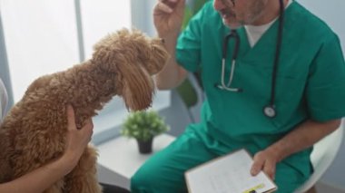 Önlüklü orta yaşlı bir veteriner parlak bir klinikte kanişi nazikçe inceliyor. Bu da profesyonel bir sağlık hizmetleri ortamı olduğunu gösteriyor..