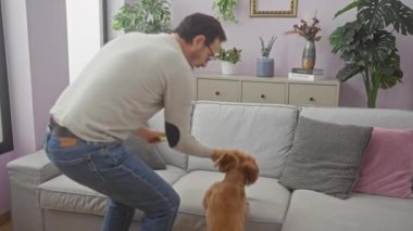 Orta yaşlı bir adam rahat bir oturma odasındaki kanepede kanişiyle bağ kurmaktan hoşlanır..