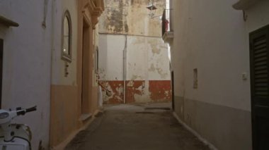 Genç İspanyol bir kadın Gelibolu, Puglia, İtalya, Avrupa 'da dar sokaklarda yürüyor. Güzel tarihi mimari ve kırsal çekiciliğin özünü yakalıyor..