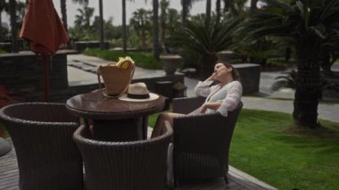 Huzurlu genç bir kadın, tropik bir kaçışı somutlaştıran lüks bir bali tatil köyünde eğleniyor..