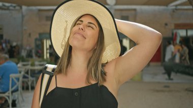 Şık şapkalı mutlu genç bir kadın geleneksel Dubai çorbası atmosferinin tadını çıkarıyor.