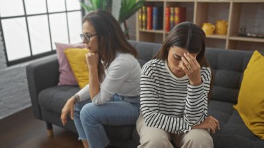 Modern bir oturma odasında iki endişeli kadın ciddi bir konuşma yapan bir anne ve kızı öneriyor..