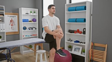 İyi donanımlı bir rehabilitasyon kliniğinde diz egzersizi yapan İspanyol bir adam.