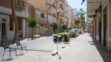 Şehir caddesinin bulanık görüntüsü odak binalarından ve ağaçlardan güpegündüz bokeh etkisi gösteren